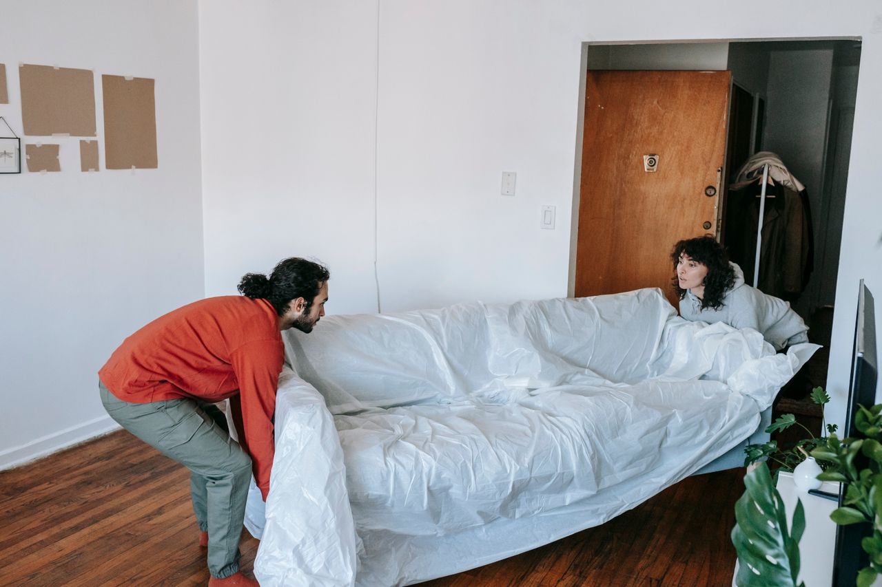 gallery-1 Un couple soulève ensemble un canapé en emménageant dans un nouvel appartement.